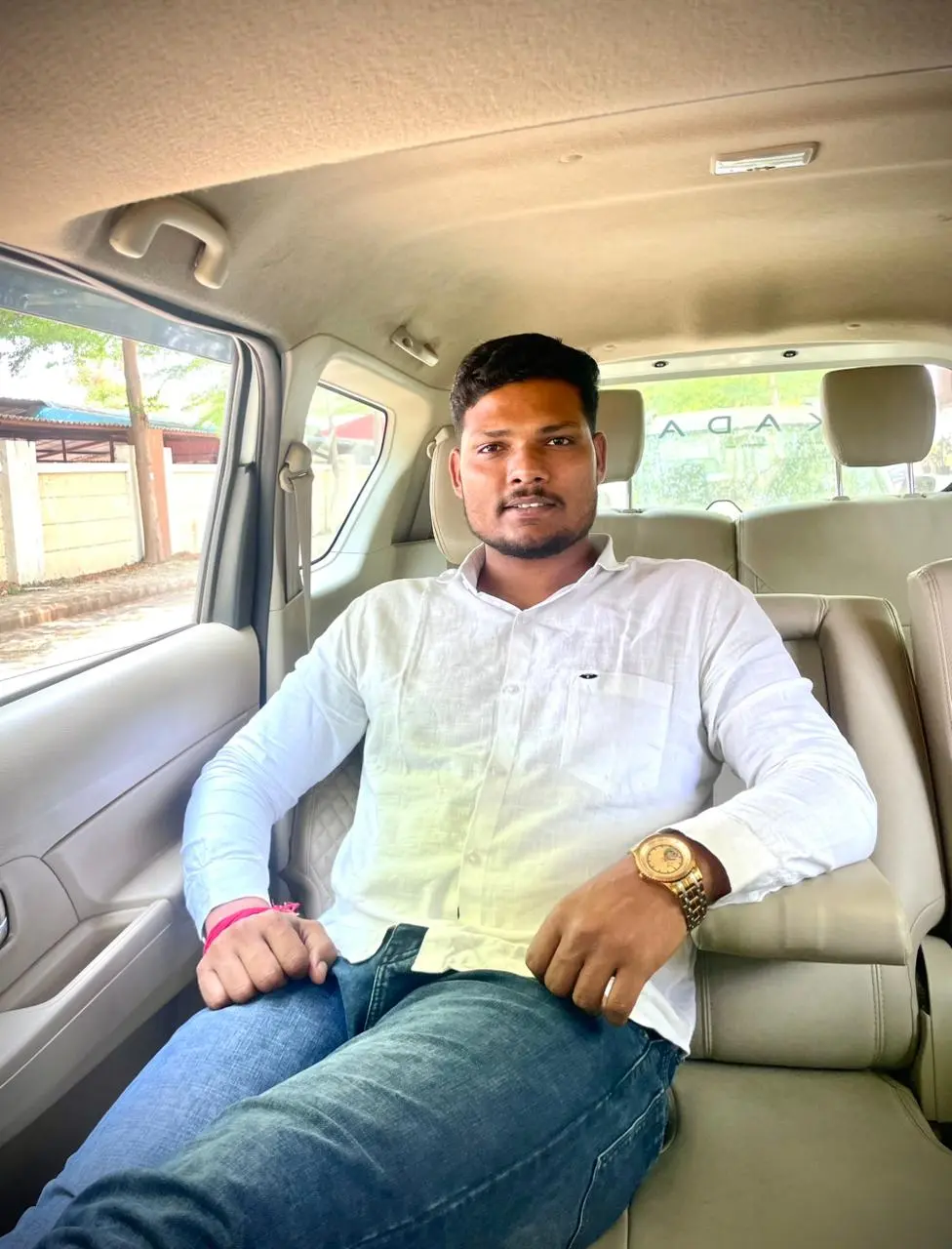 Owner of Kadam Tours and Travels sitting inside cab in Pune providing reliable travel service